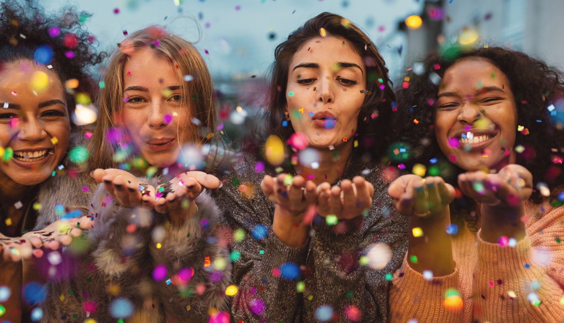 Unas chicas soplando confeti.